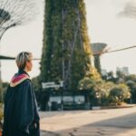 woman in black coat standing on road during daytime