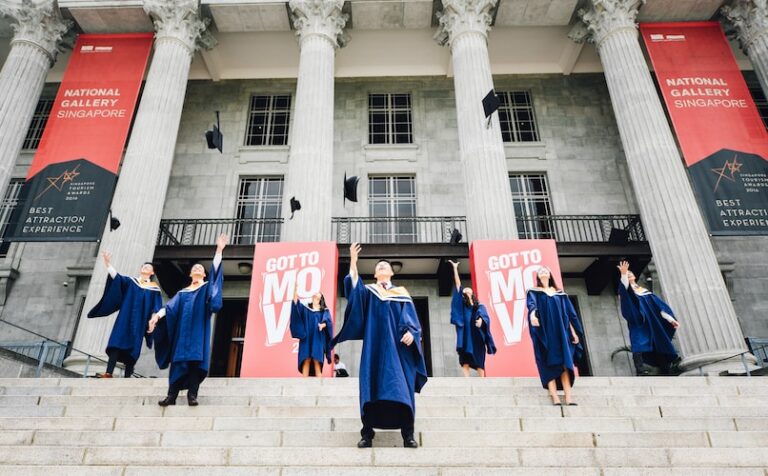 graduates in front of building