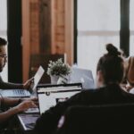 selective focus photography of people sits in front of table inside room